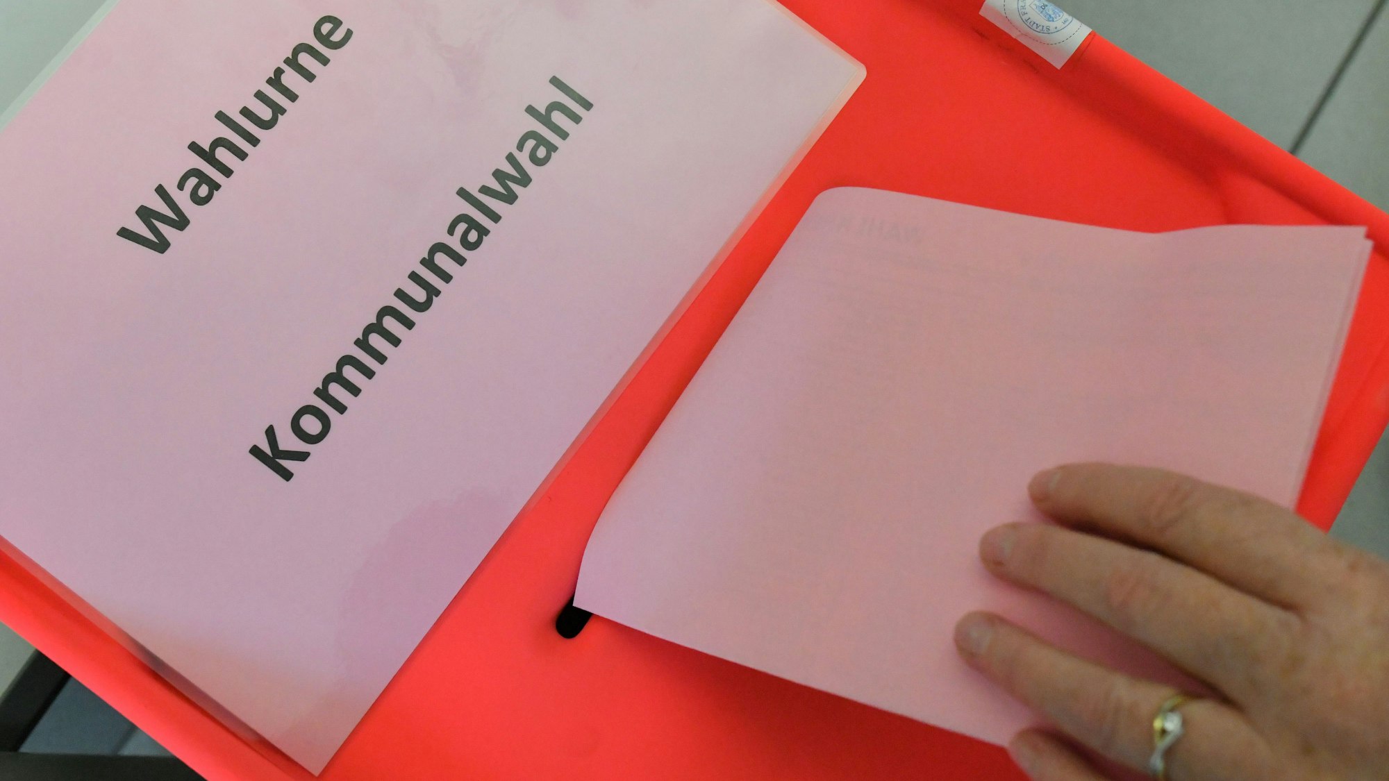 Eine Wählerin steckt ihren Stimmzettel zur Kommunalwahl in die Wahlurne.