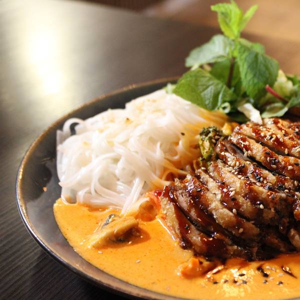 Gastronomische Einflüsse aus verschiedenen asiatischen Ländern: Curry mit knuspriger Ente, saisonalem Gemüse und Reisbandnudeln.