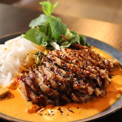 Gastronomische Einflüsse aus verschiedenen asiatischen Ländern: Curry mit knuspriger Ente, saisonalem Gemüse und Reisbandnudeln.