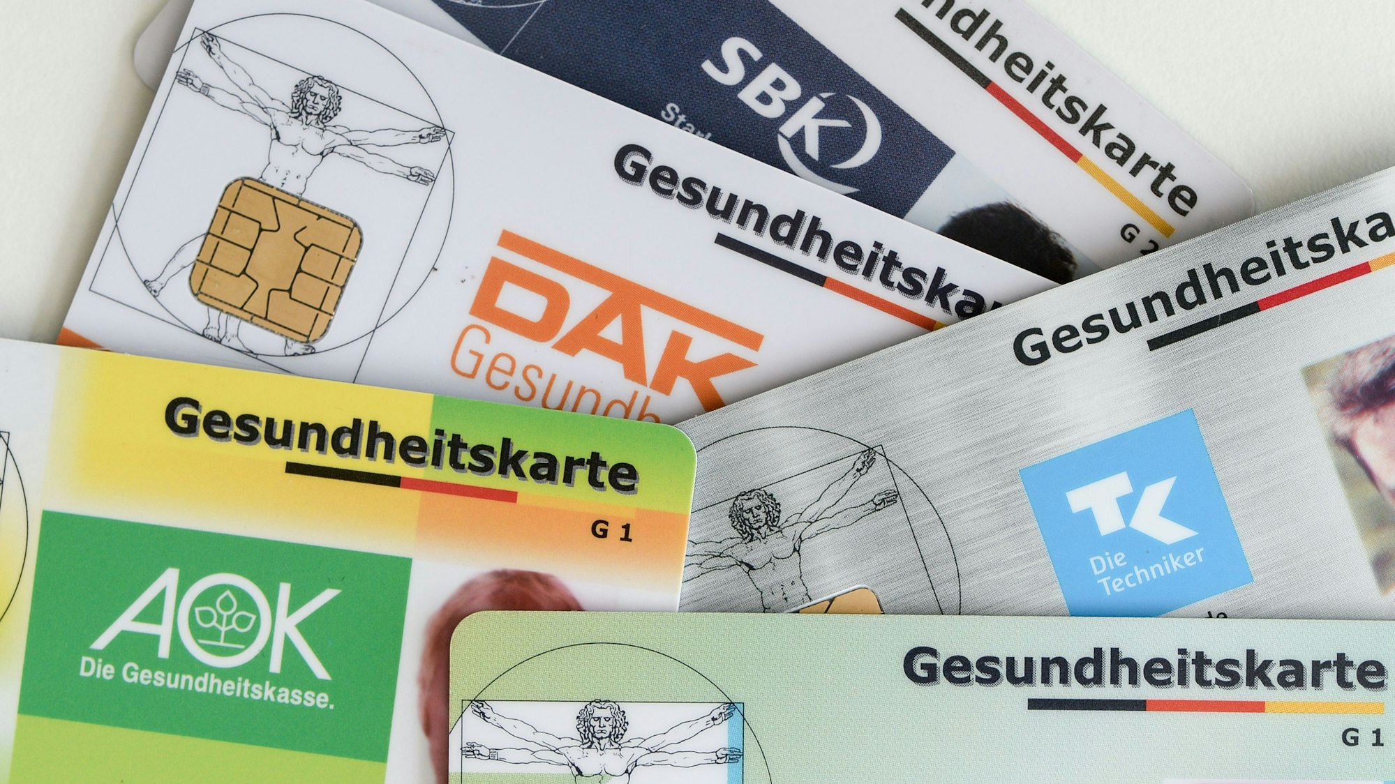 Gesundheitskarten verschiedener Krankenkassen liegen auf einem Tisch. (Symbolbild)
