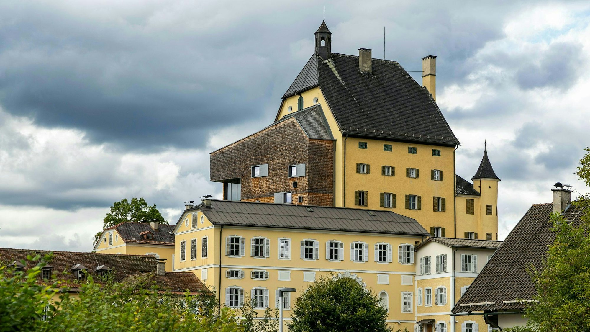 Das gelb getünchte Kloster Goldenstein vor bewölktem Himmel.