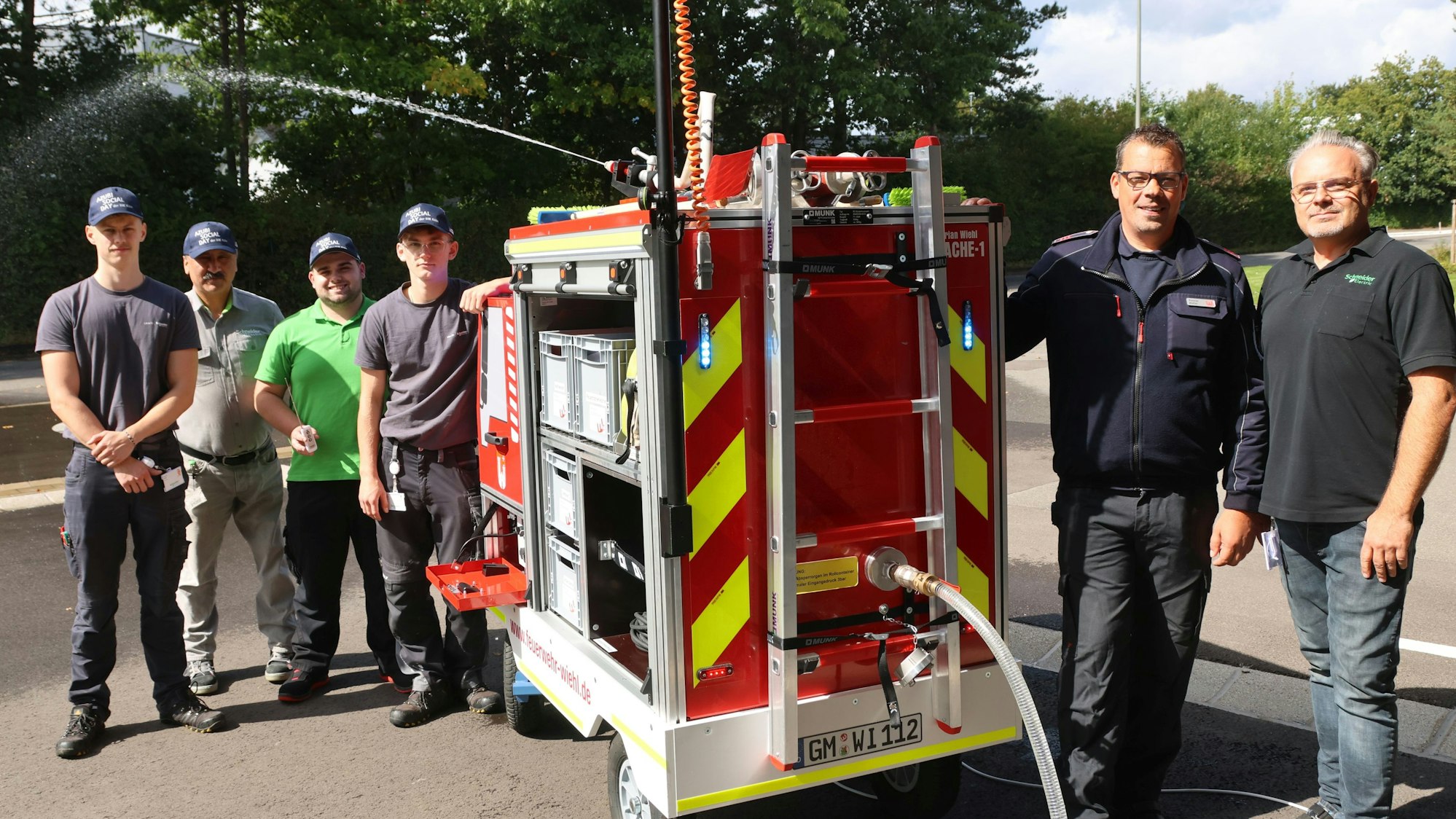 Bild einer Menschengruppe rund um ein Kinderfeuerwehrauto