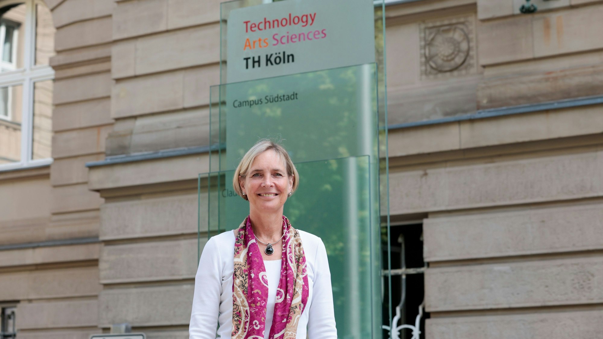 Die Präsidentin der TH Köln steht vor dem Gebäude des Campus Südstadt.
