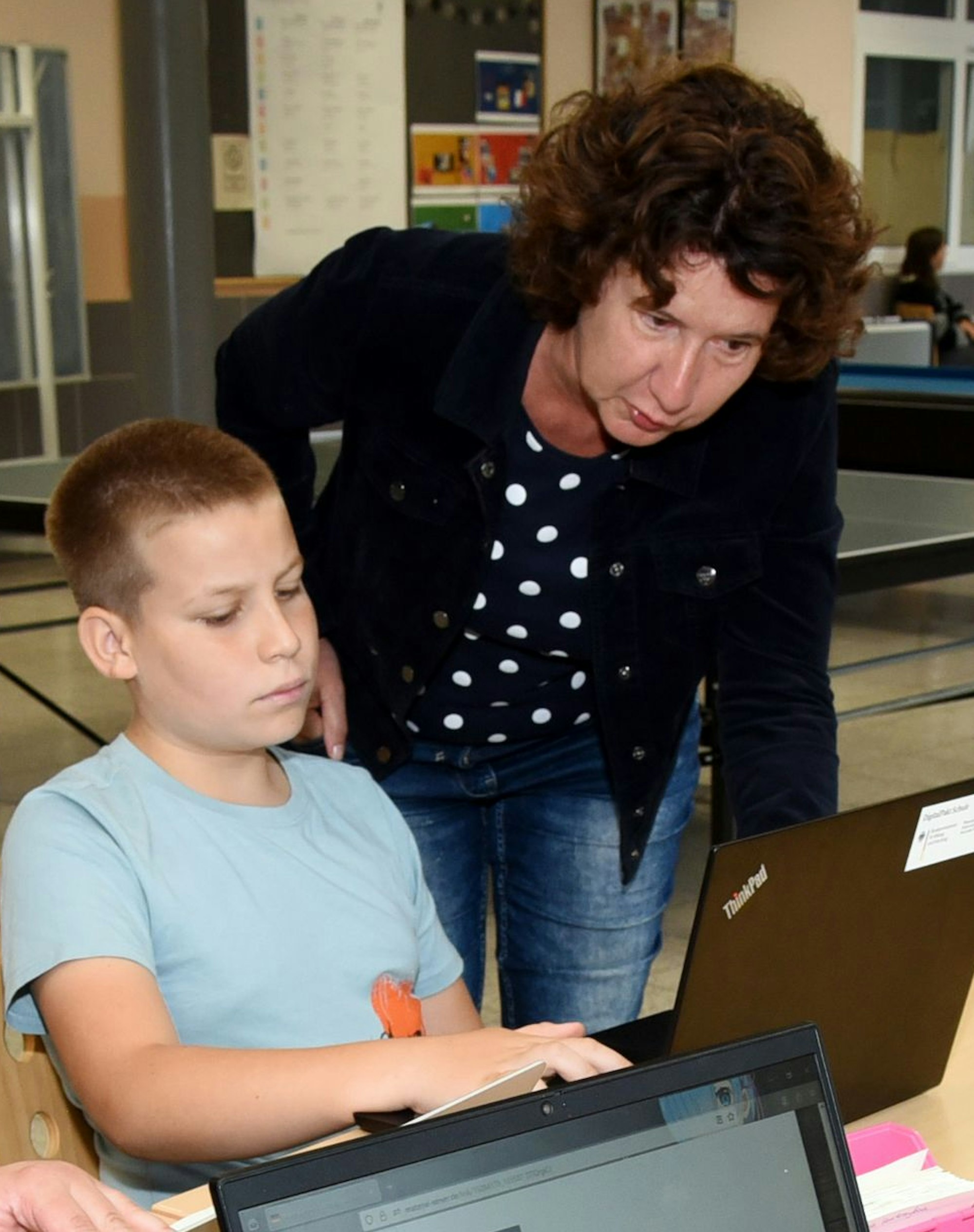 Antje Zschetke vom Kommunalen Integrationszentrum des Oberbergischen Kreises schaut Illia (11) aus der Ukraine über die Schulter.