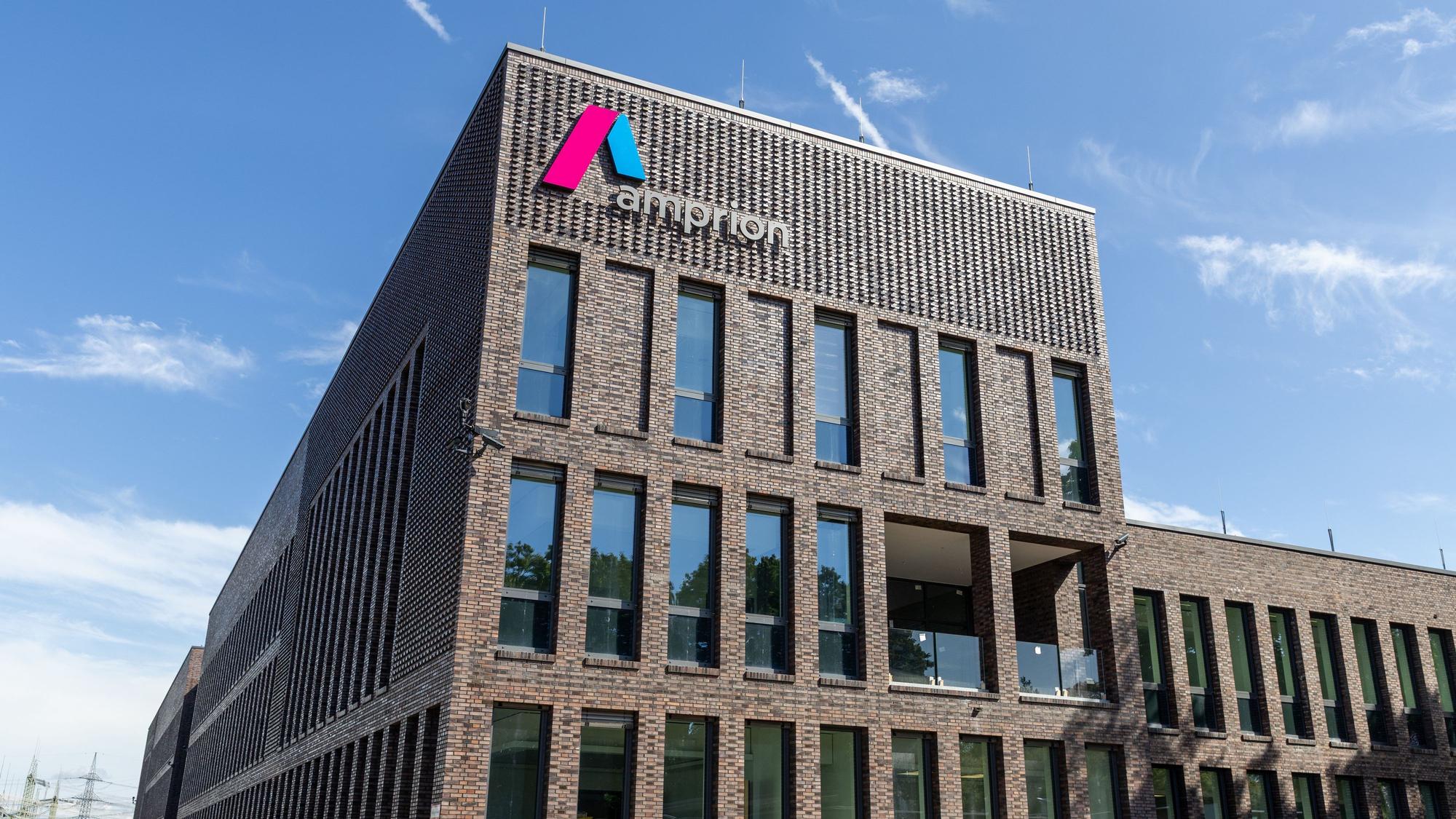 Das Foto zeigt eine Außenansicht des Neubaus mit Amprion-Logo auf der Fassade.