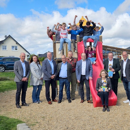 Offizielle Vertreter stehen vor dem Spielschiff, Kinder sitzen jubelnd im Ausguck.