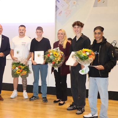 Auf dem Bild ist eine Gruppe von Menschen bei einer Ehrung zu sehen.