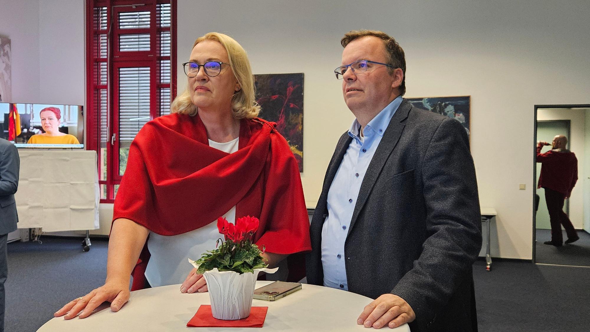 SPD-Kandidatin Iris Heinisch (l.) und SPD-Kreisvorsitzender Helge Herrwegen schauen im Kreishaus gebannt auf die Leinwand, auf der die Ergebnisse der Kommunalwahl eingeblendet werden.