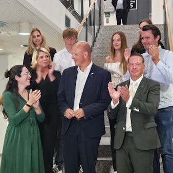 Zu sehen ist eine Gruppe von Menschen auf einer Treppe.