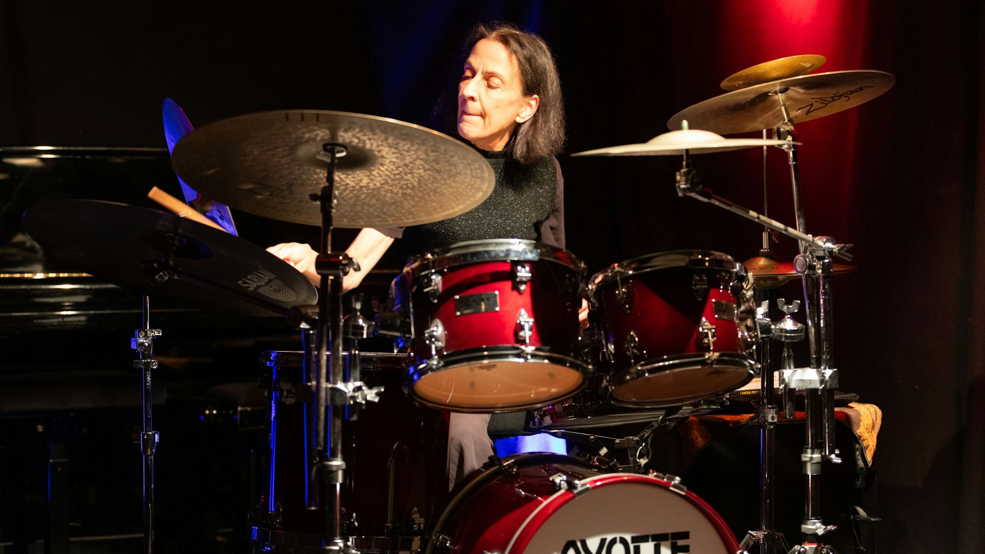 Eine Schlagzeugerin bei einem Konzert auf einer Bühne.