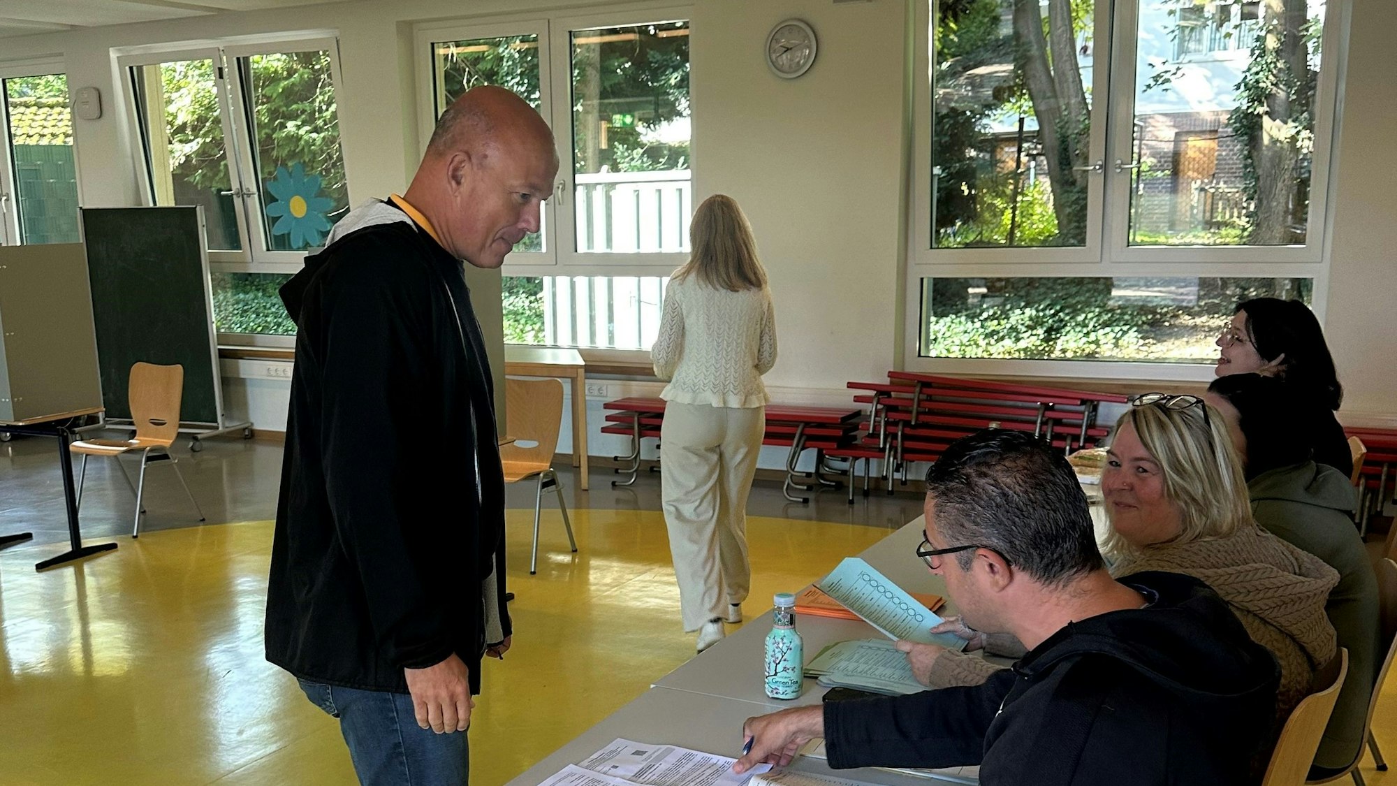 Auf dem Bild sind Wähler und Wahlhelfer in einem Wahllokal zu sehen.