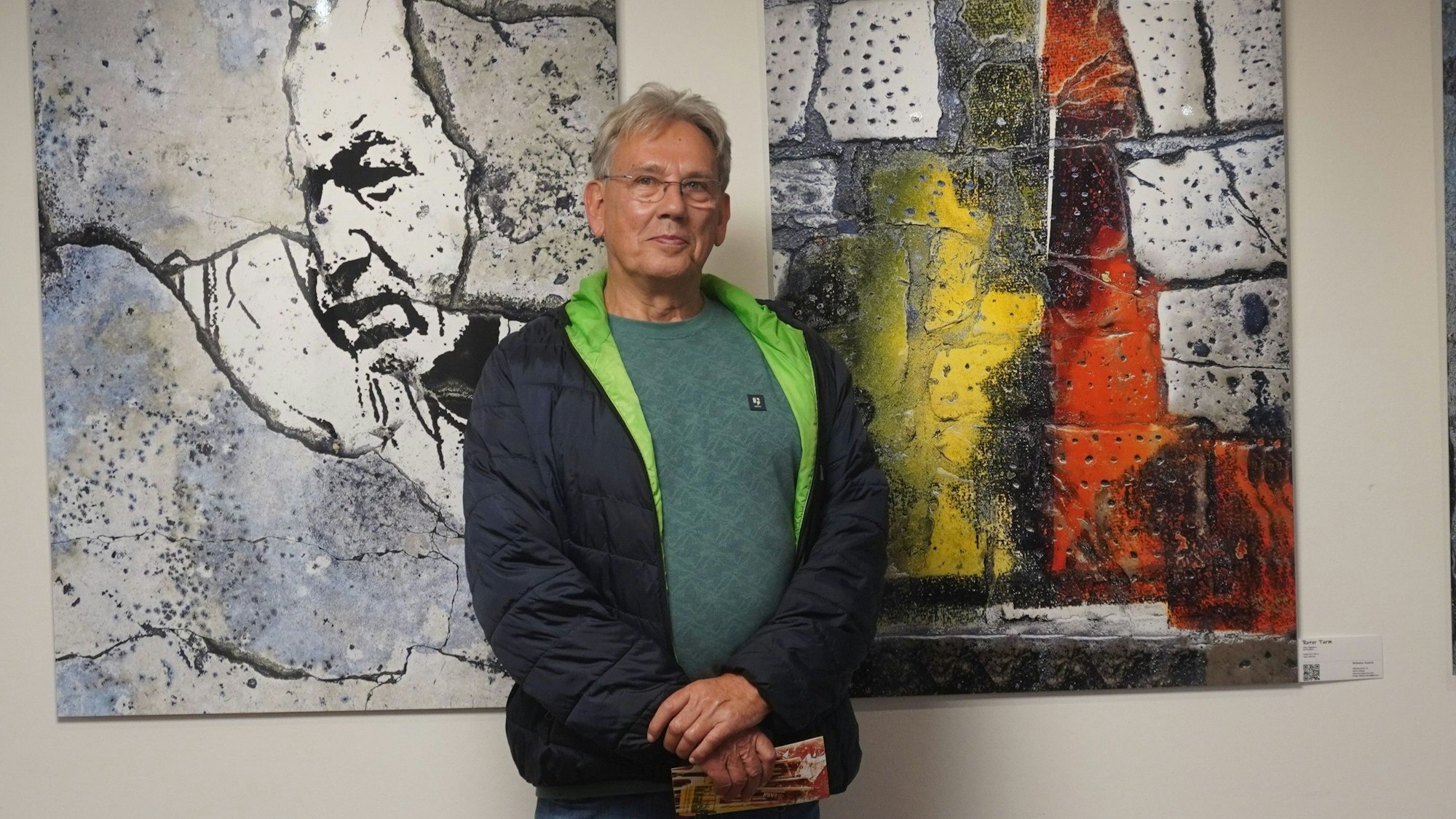 Zu sehen ist Wilhelm Goertz vor zwei seiner Werke.