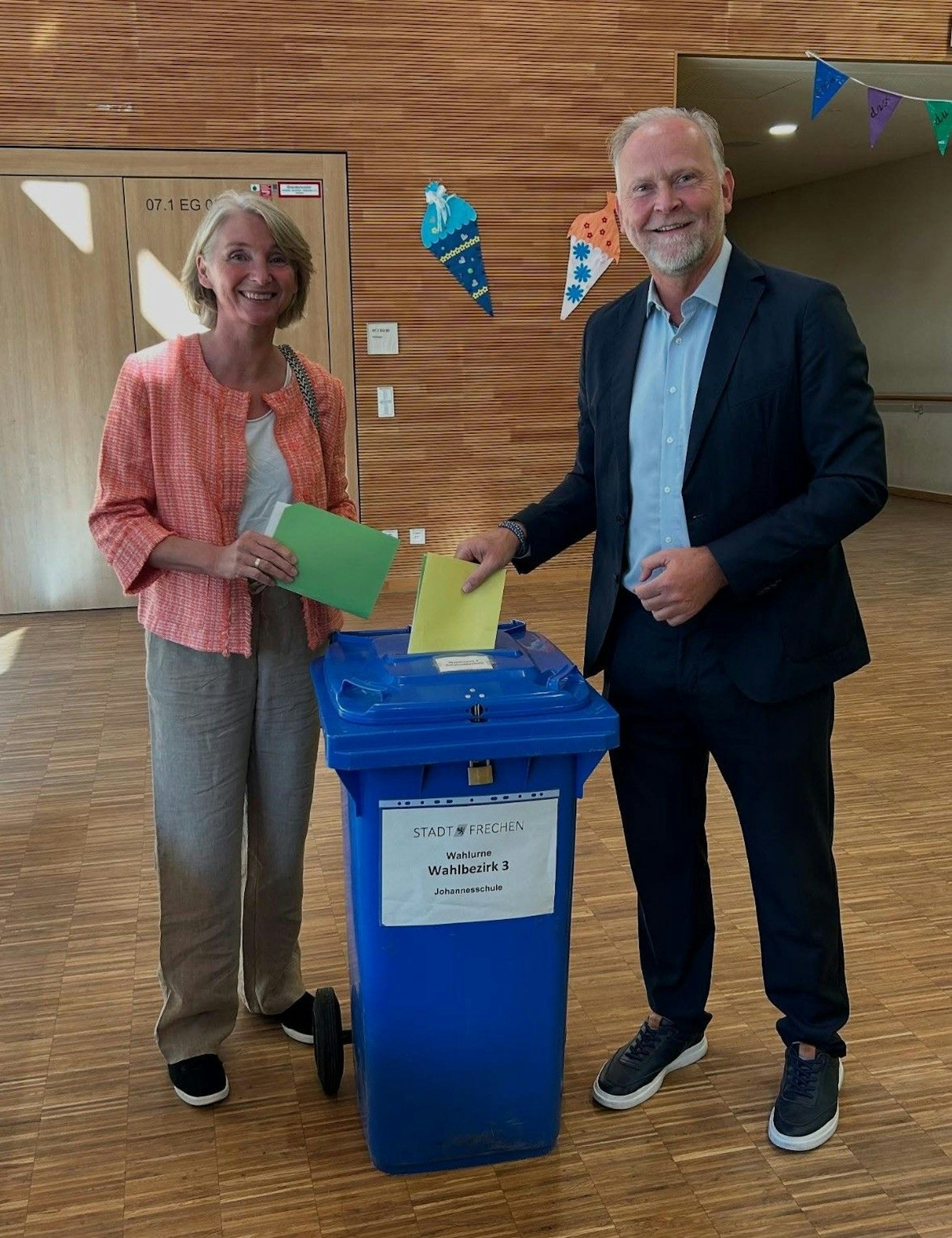 Auf dem Bild ist ein Ehepaar beim Wahlgang zu sehen.