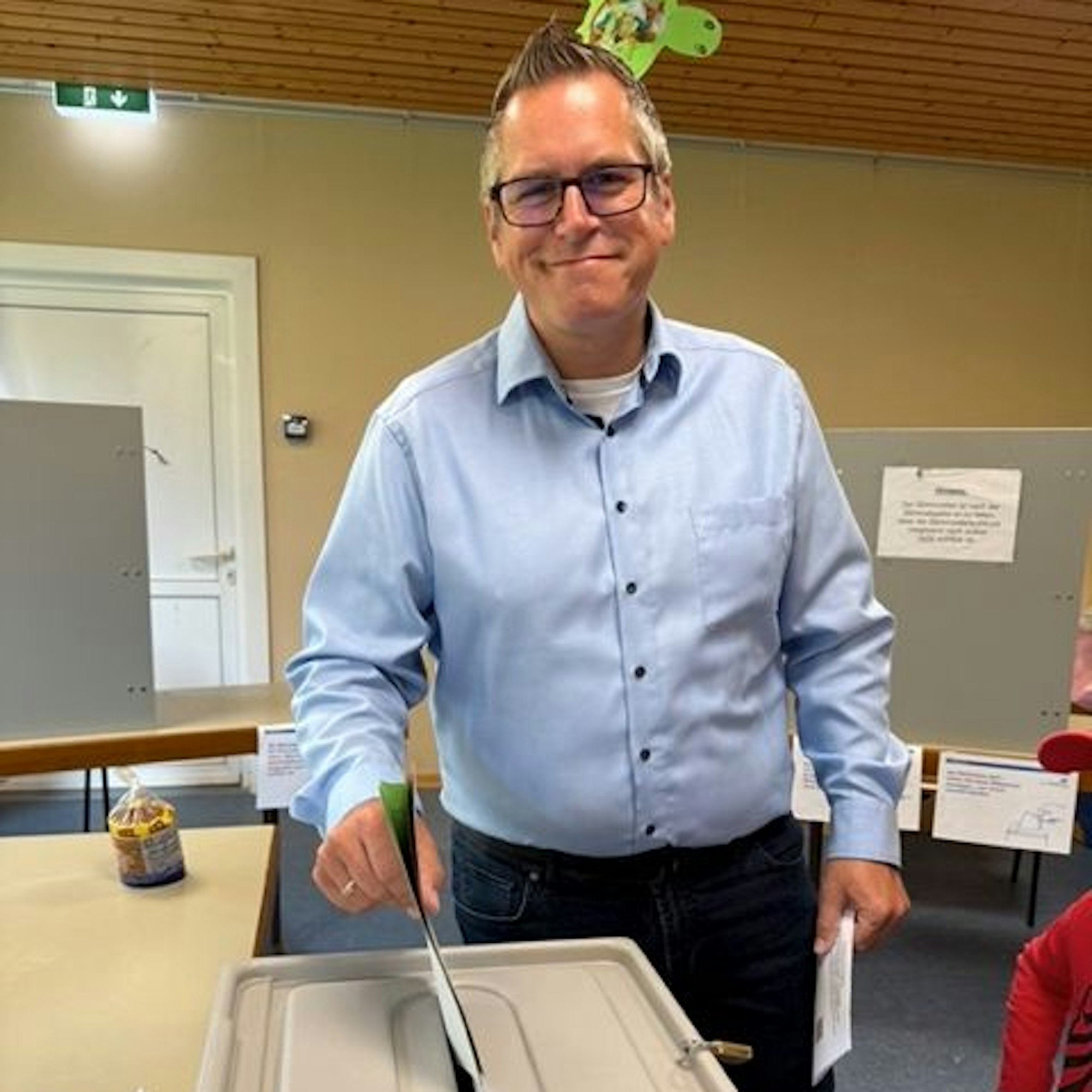 Auf dem Bild ist ein Mann an der Wahlurne zu sehen.