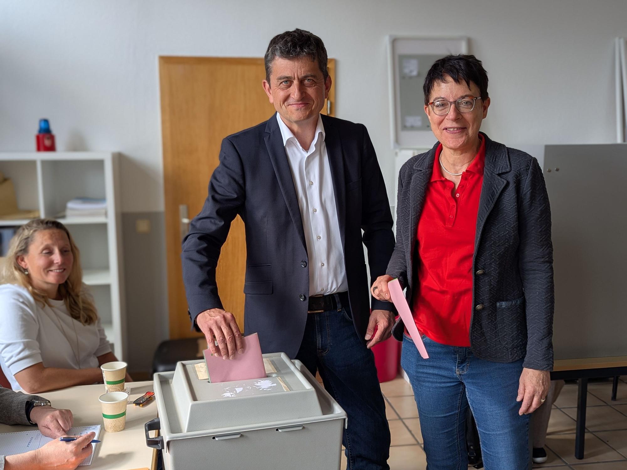 Das Foto zeigt die Kandidaten bei der Stimmabgabe an der Wahlurne im Wahllokal.