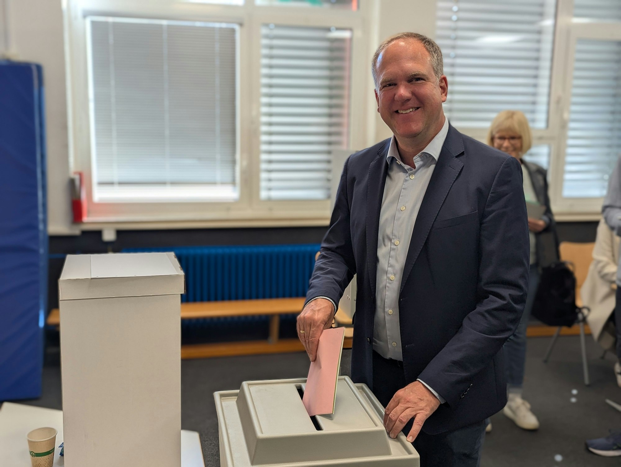 Das Foto zeigt, wie Bürgermeister und CDU-Kandidat Dirk Breuer die Stimmzettel in die Wahlurne wirft.