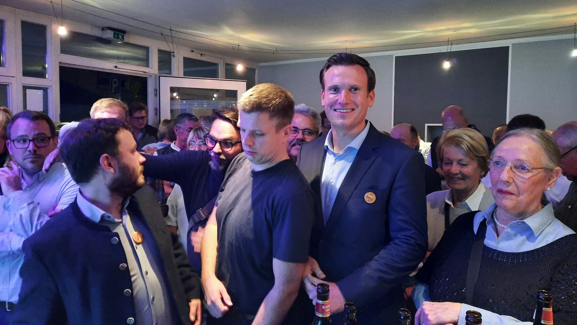 Eine Gruppe von Menschen drängt sich in einem Raum.