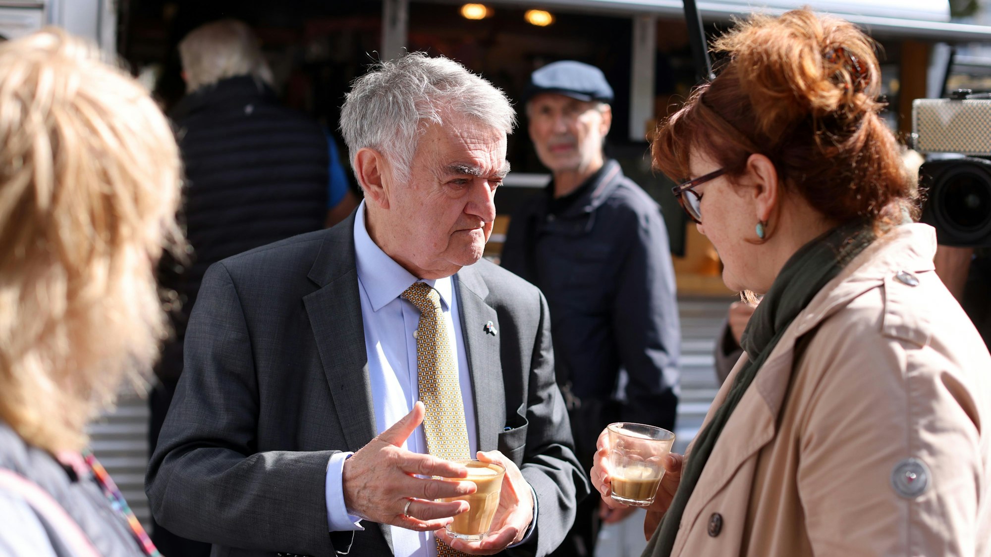 NRW-Innenminister Herbert Reul unterhält sich bei einer Tasse Kaffee mit einer Bürgerin bei der Aktion „Coffee with a Cop“.