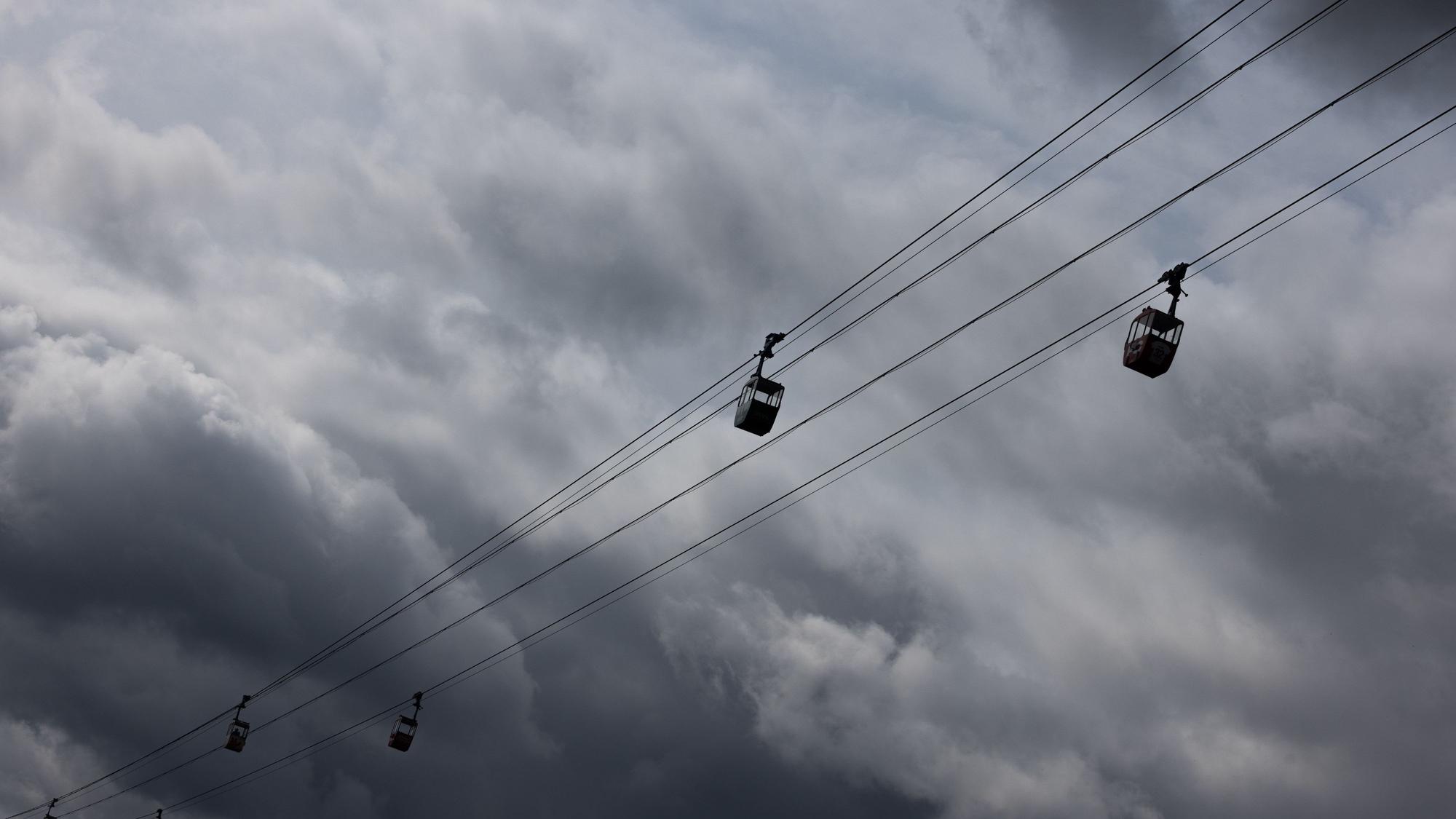 Die Seilbahn über den Rhein ist vor dunklen Wolken am Himmel zu sehen. Zu Pfingsten soll sich das Wetter drehen. (Archivbild)