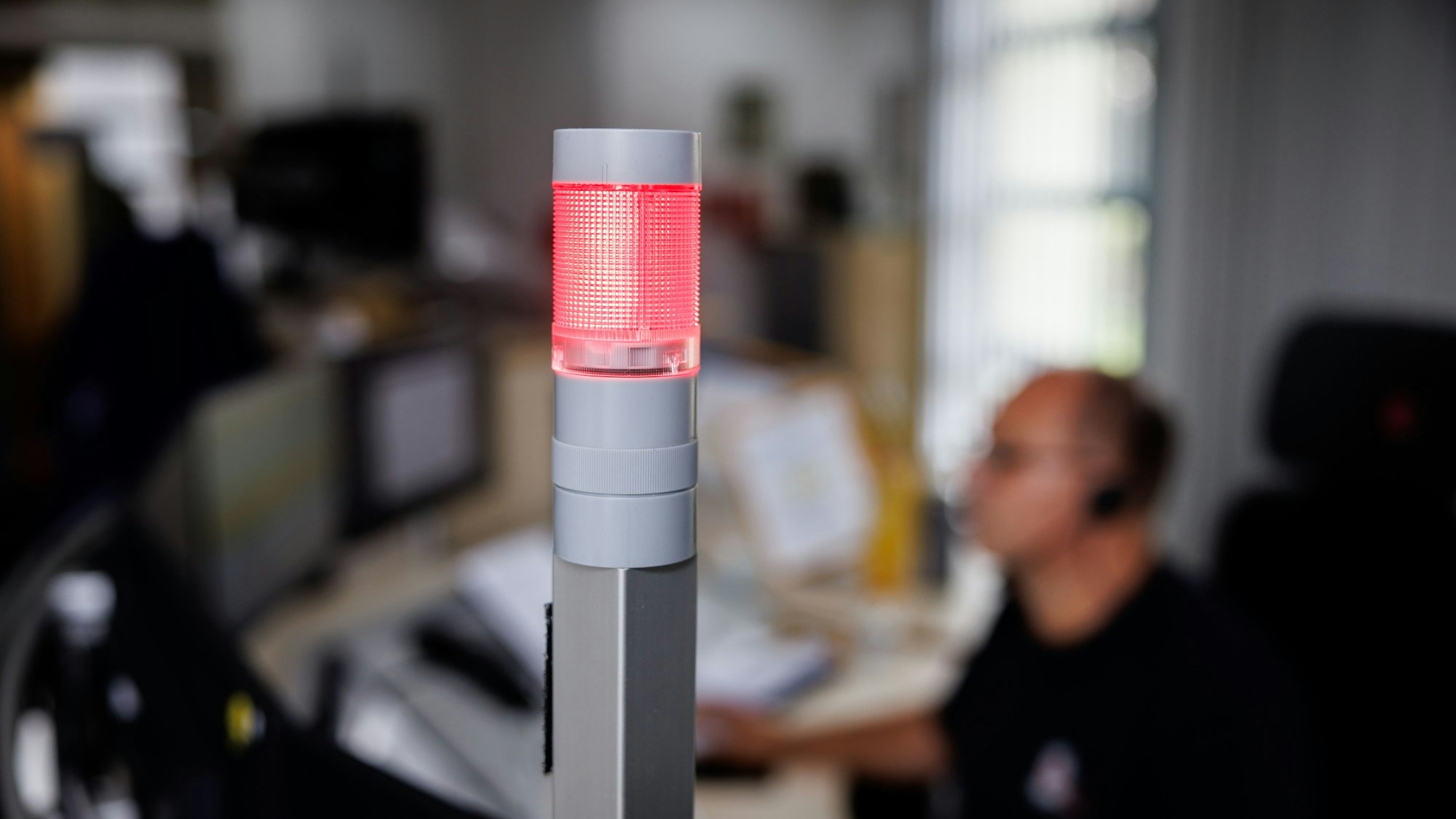 Ein Leitstellendisponent nimmt in der integrierten Leitstelle vom Bayerischen Roten Kreuz einen Notruf entgegen.