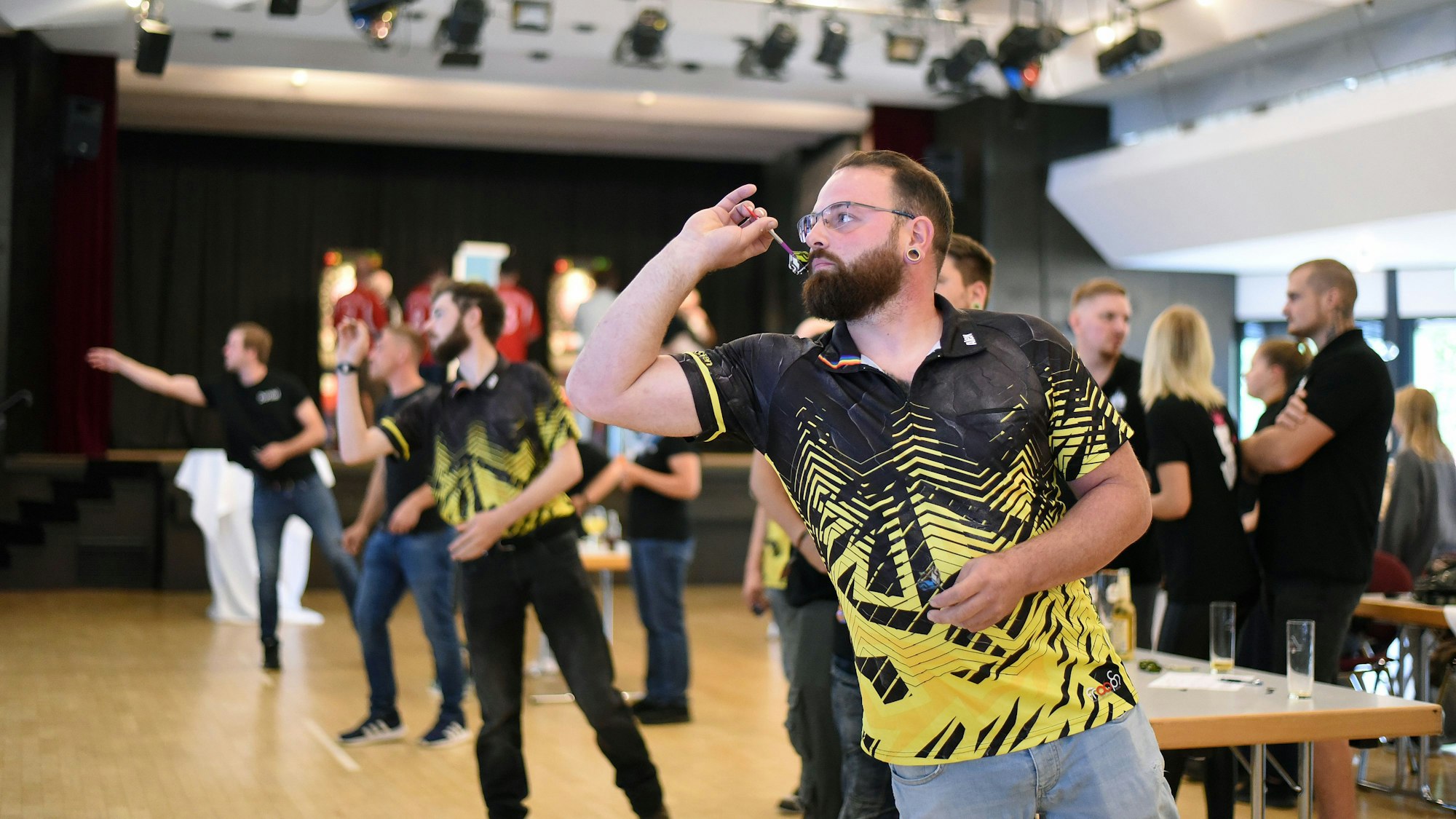 Ein Mann wirft einen Pfeil auf eine E-Dartscheibe.