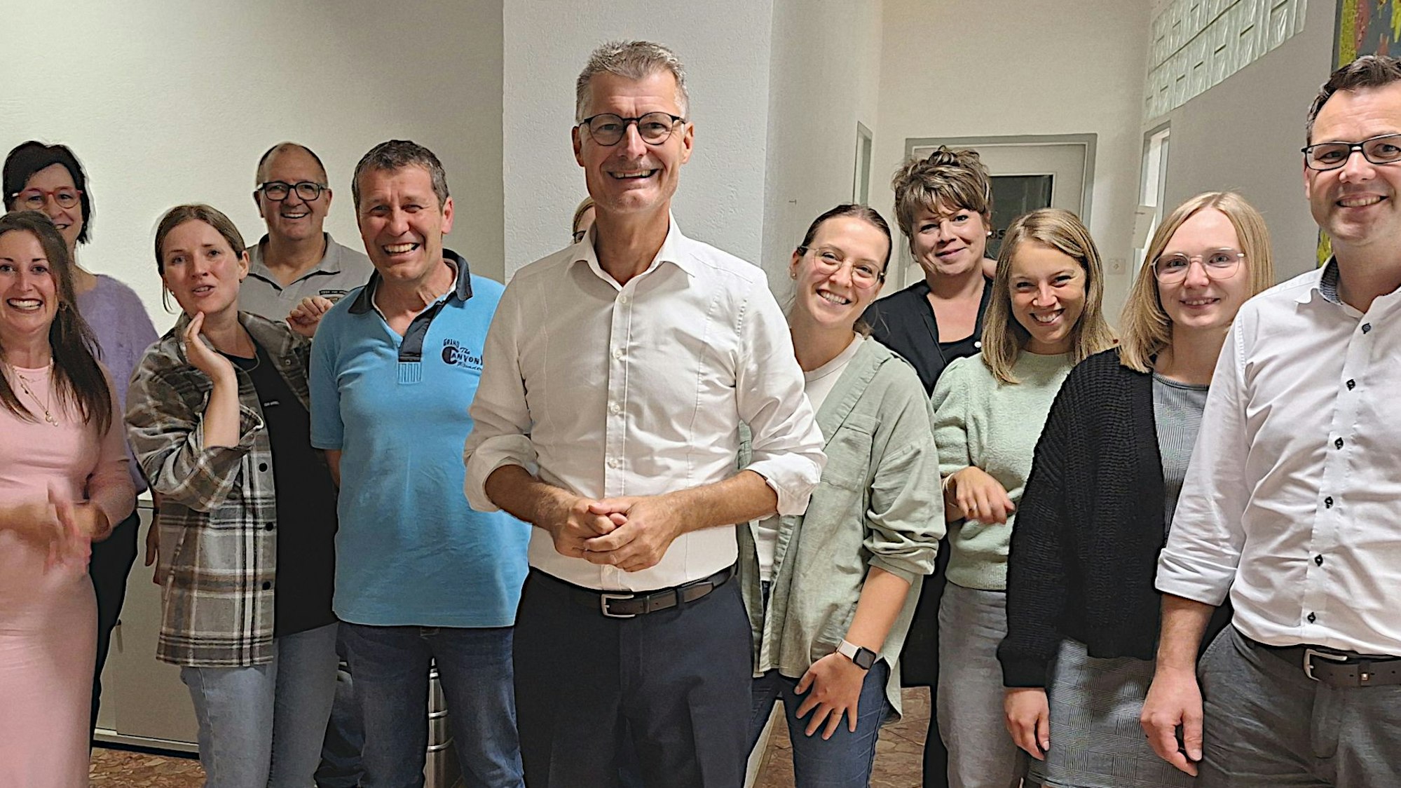 Das Bild zeigt eine Gruppe von Männern und Frauen, in der Mitte steht Jan Lembach.