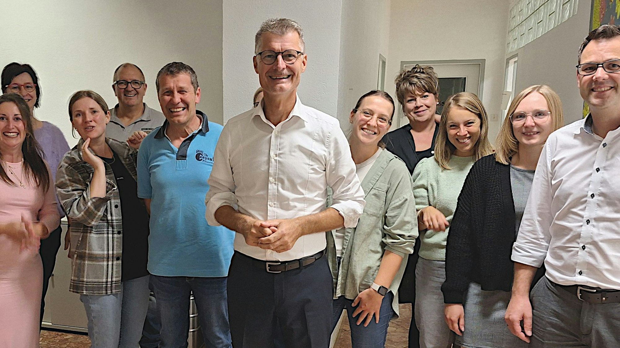 Das Bild zeigt eine Gruppe von Männern und Frauen, in der Mitte steht Jan Lembach.