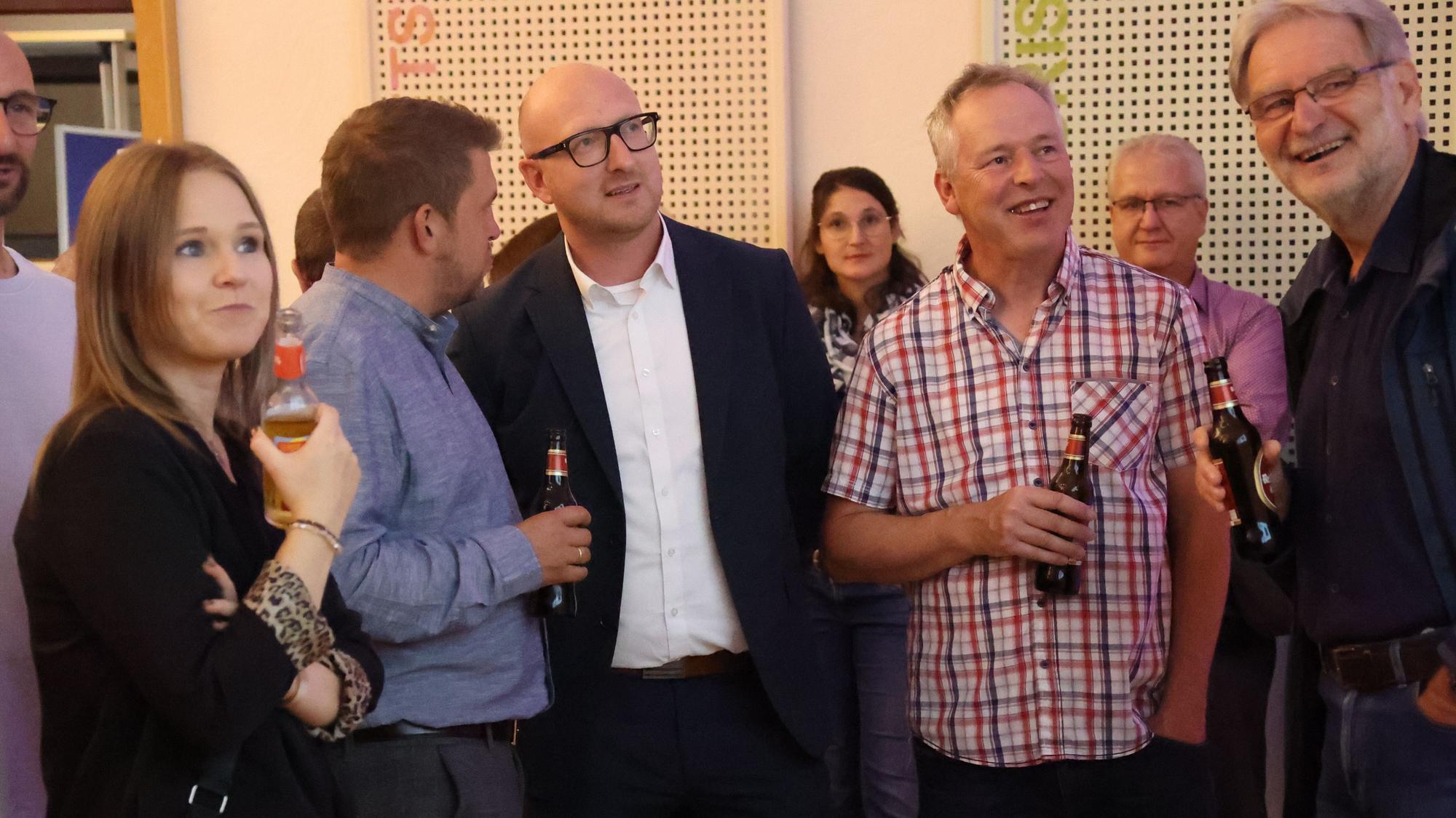 Ingo Pfennings und einige andere Personen verfolgen die Wahlergebnisse.