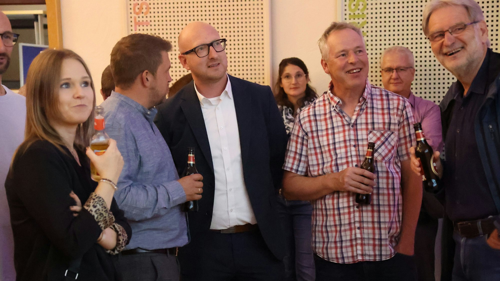 Ingo Pfennings und einige andere Personen verfolgen die Wahlergebnisse.