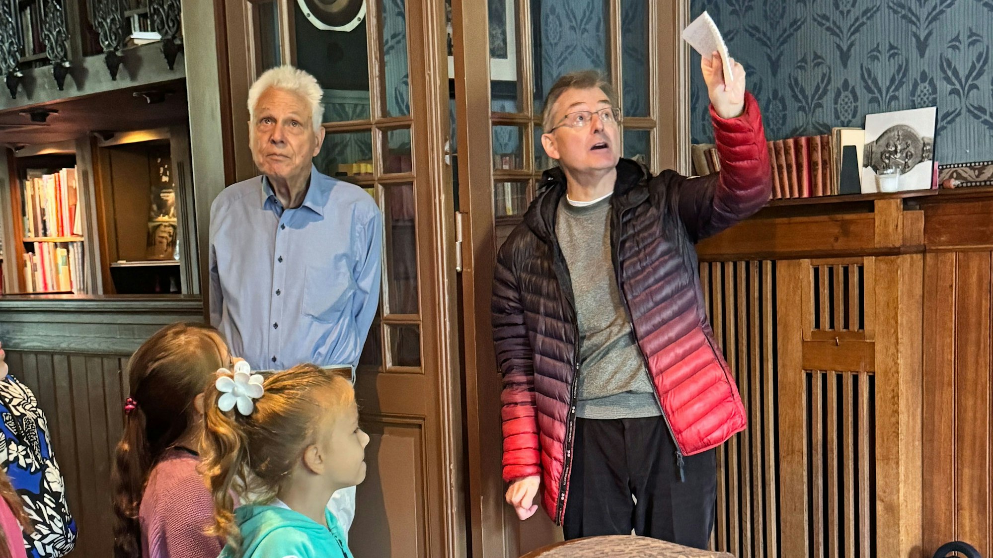 Das Foto zeigt zwei Männer und Kinder im Rittersaal.