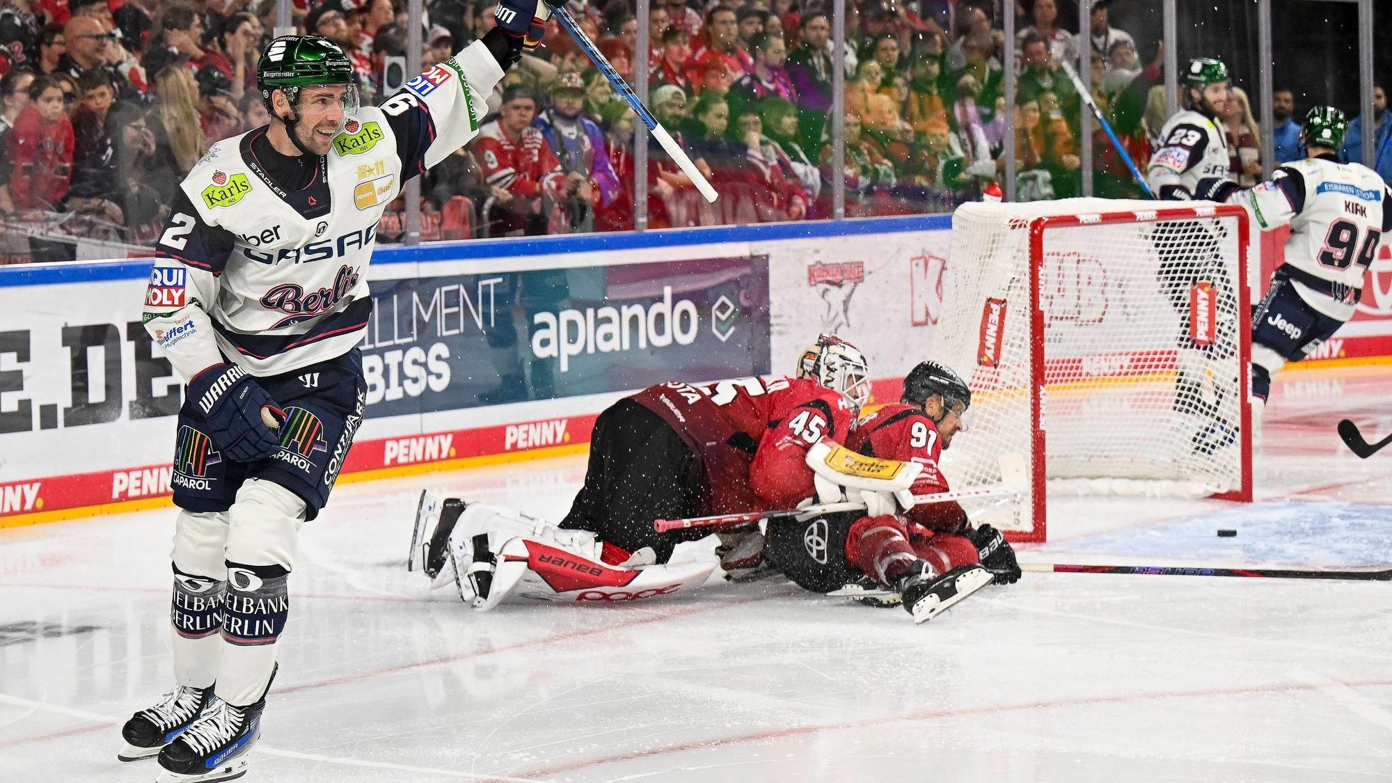 Sinnbildlich: Marcel Noebels (l.) jubelt über das 5:3 für Berlin, während Haie-Goalie Tobias Ancicka und Kapitän Moritz Müller geschlagen auf dem Eis liegen.