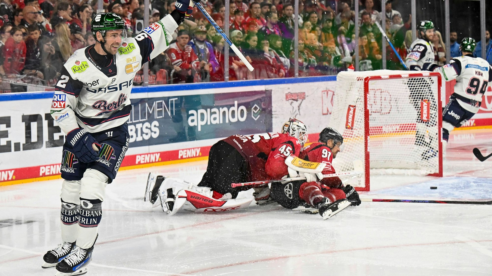Sinnbildlich: Marcel Noebels (l.) jubelt über das 5:3 für Berlin, während Haie-Goalie Tobias Ancicka und Kapitän Moritz Müller geschlagen auf dem Eis liegen.