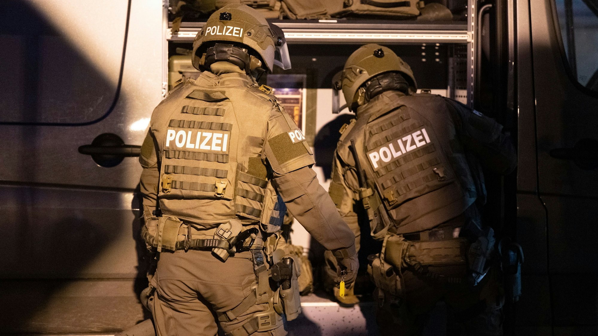 Beamte eines Spezialeinsatzkommandos (SEK) der Polizei agieren in einem Wohngebiet.