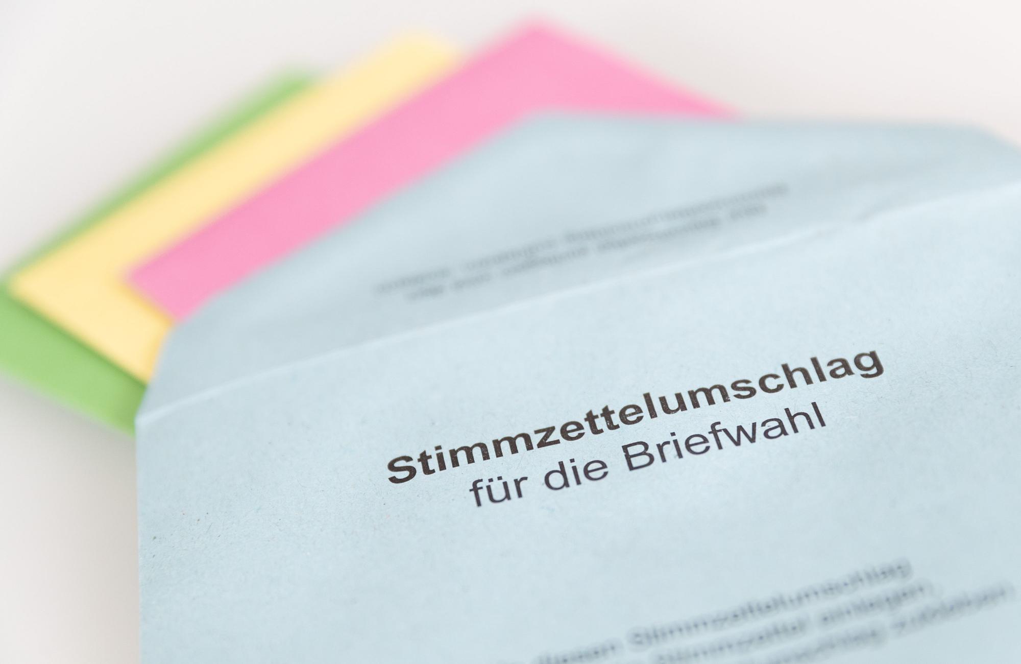 Verschiedene Stimmzettel stecken in einem Stimmzettelumschlag für die Briefwahl. (Symbolbild)
