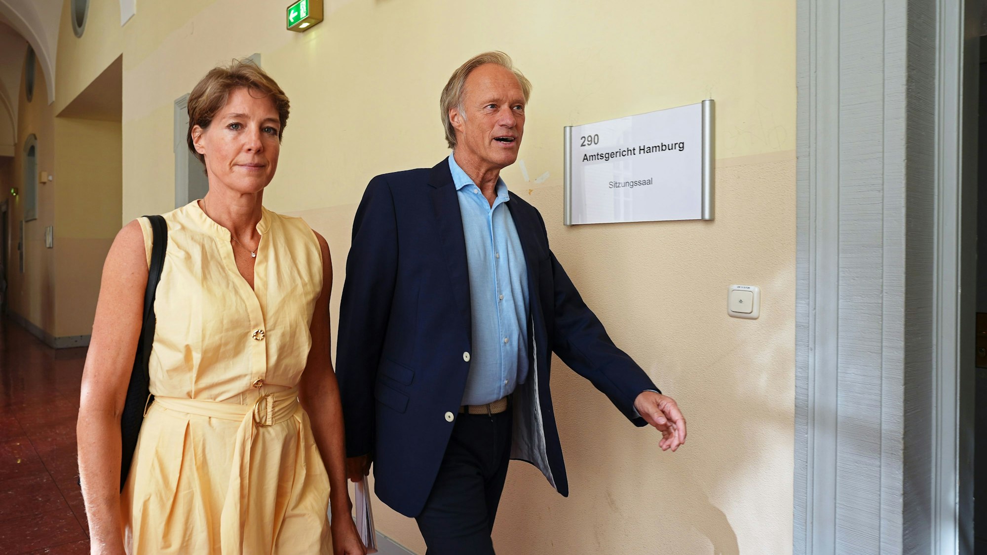 Christina Block (l.), deutsche Gastronomin und Unternehmerin, und Gerhard Delling, ehemaliger Sportmoderator und Lebensgefährte von Block, kommen nach einer Pause im Prozess wegen mutmaßlicher Kindesentführung zum Gerichtssaal im Landgericht Hamburg zurück. (Archivbild)