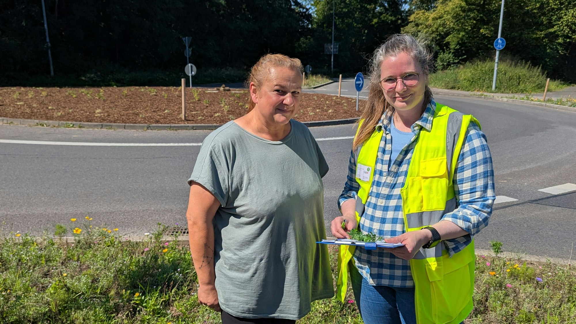 Das Foto zeigt zwei Frauen mit einem Klemmbrett vor dem Kreisverkehr an der Theresienhöhe am Hürth-Park.