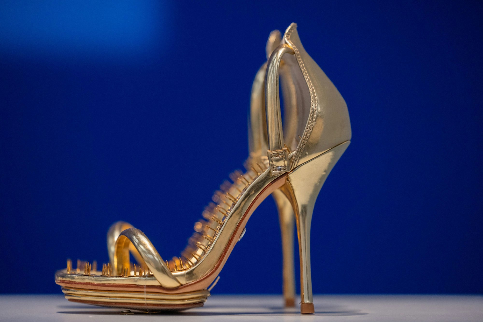 Das Werk „Goldene Schuhe mit Heftzwecken“ (ca. 2010) ist in der Ausstellung „Hans-Peter Feldmann. Kunstausstellung“ zu sehen.