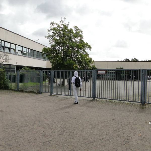 Eingang zum Schulhof und -Gebäude der Heinrich-Böll-Gesamtschule in Chorweiler.