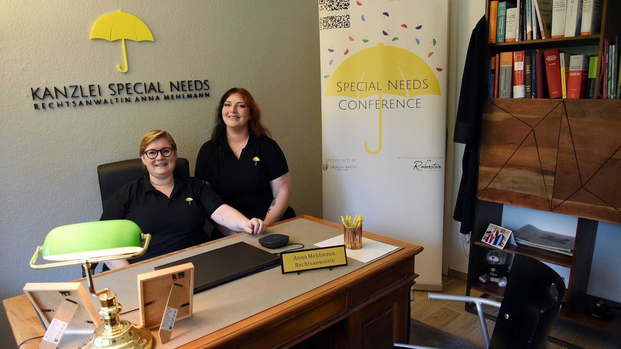 Zwei Frauen sitzen in einem Büro ihrer Kanzlei.