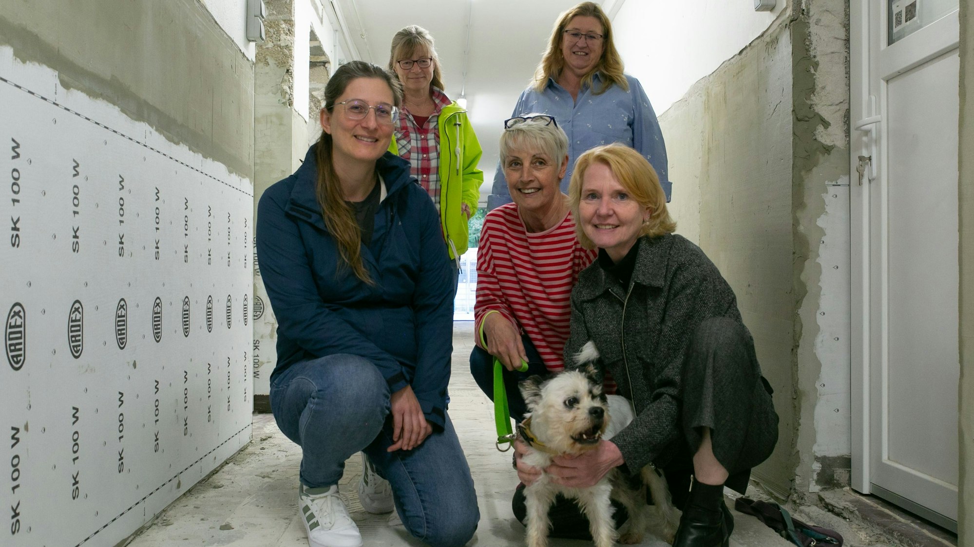 Fünf Frauen mit einem kleinen Hund.