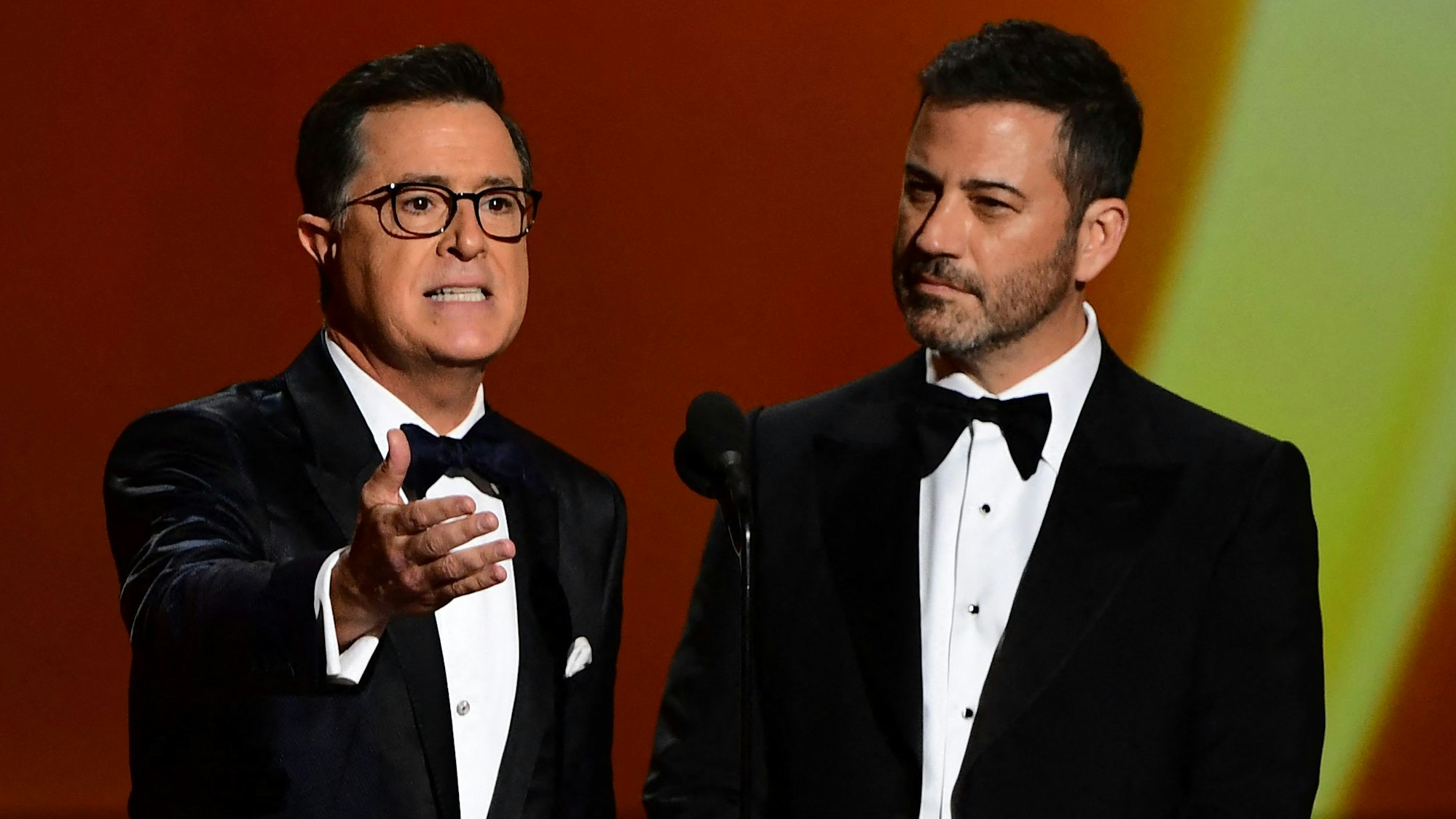 Late-Night-Moderatoren Stephen Colbert (l.) und Jimmy Kimmel sprechen auf einer Bühne.