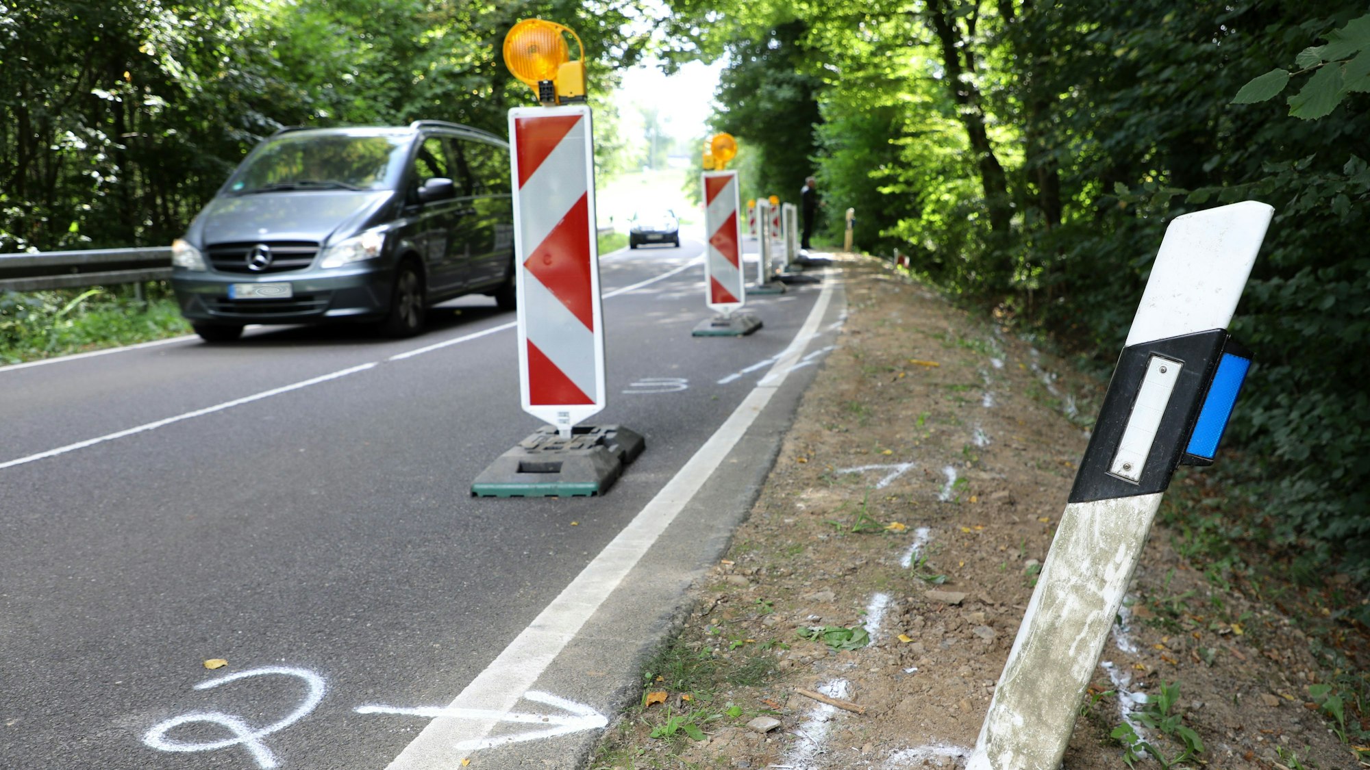 Warnbarken und Unfallmarkierungen sind in einer Kurve der Dürschtalstraße bei Kürten-Dürscheid zu sehen.