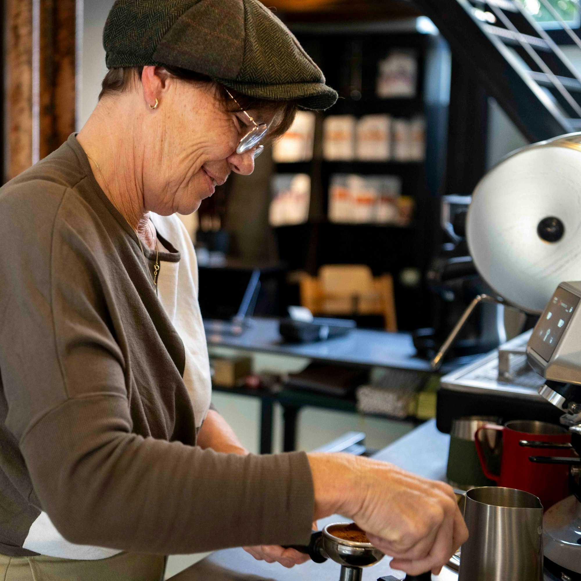 Das Bild zeigt Margret Neugebauer hinter einer Kaffeemaschine in Café Amann.