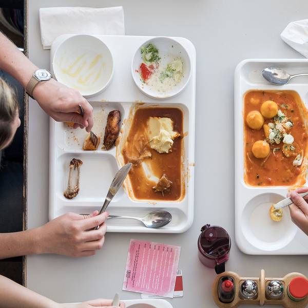 Zwei Studentinnen essen in einer Mensa.