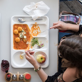 Zwei Studentinnen essen in einer Mensa.