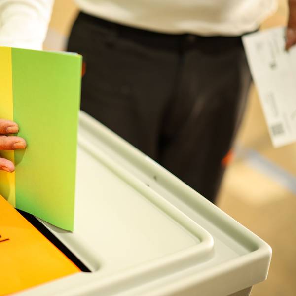 Ein Mann wirft seine Stimmzettel in eine Wahlurne.