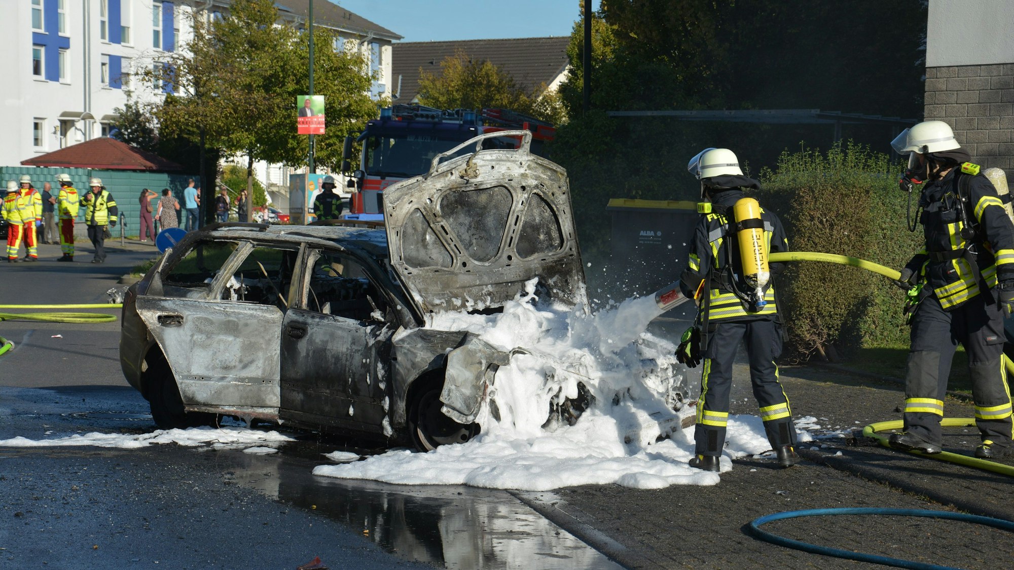 Die Feuerwehr löscht ein brennendes Fahrzeug nach einem Unfall in Kerpen-Sindorf.