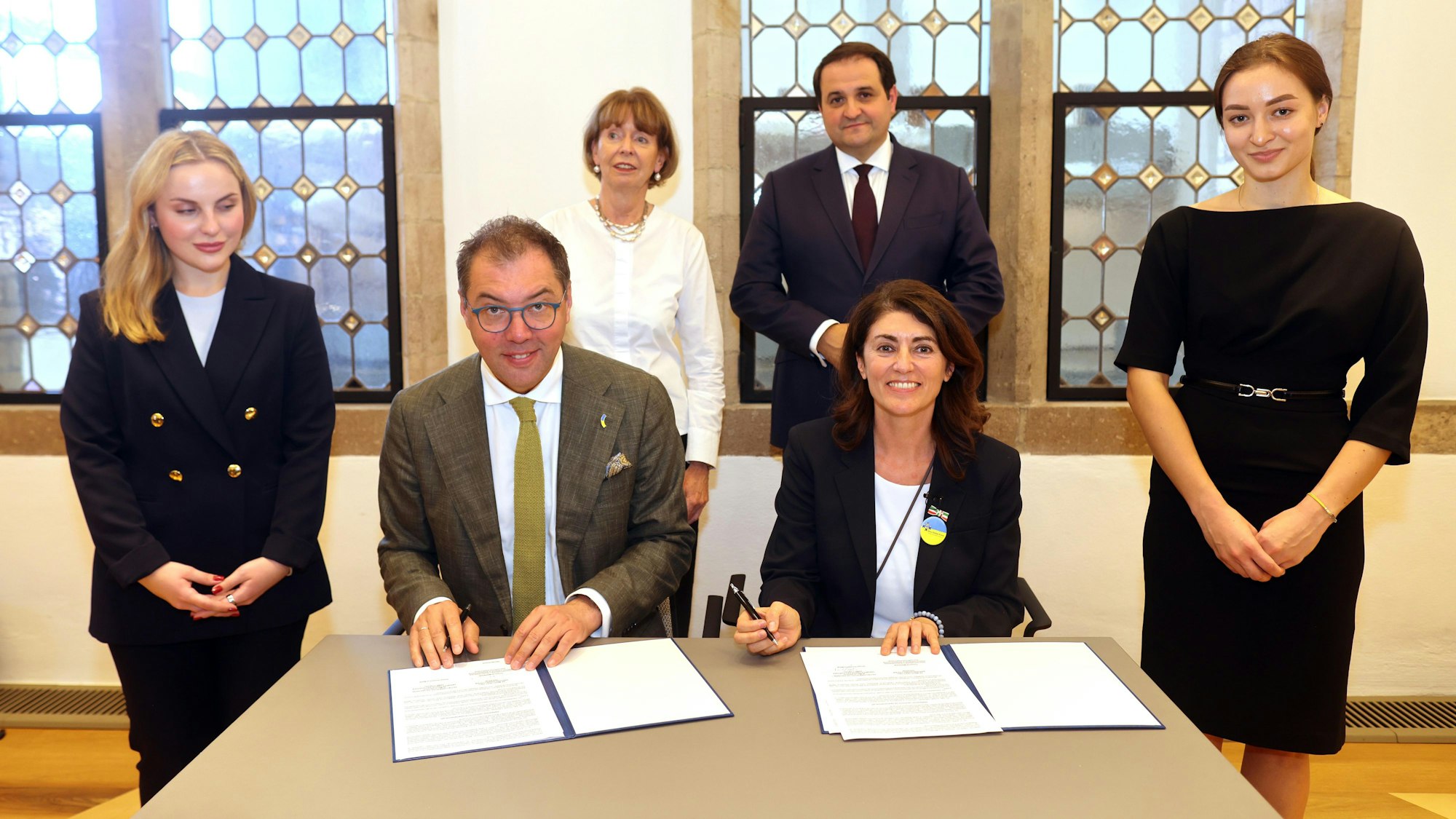 Linda Mai und Botschafter Oleksii Makeiev unterzeichnen die Unterlagen.