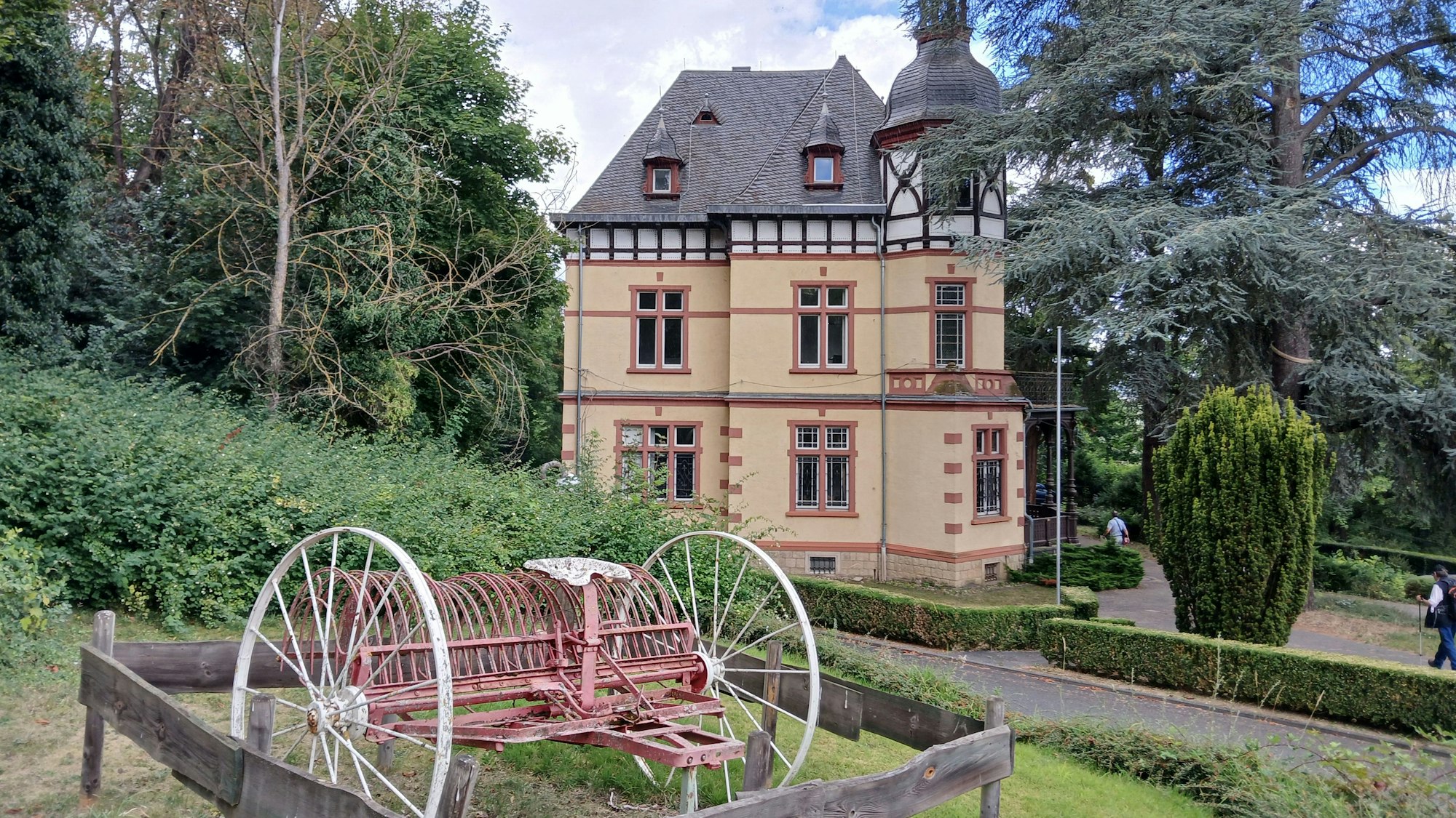 Die Villa von Brauereibesitzer Anton Nagelschmidt steht in einem Park. Ein altes landwirtschaftliches Gerät ist davor ausgestellt.