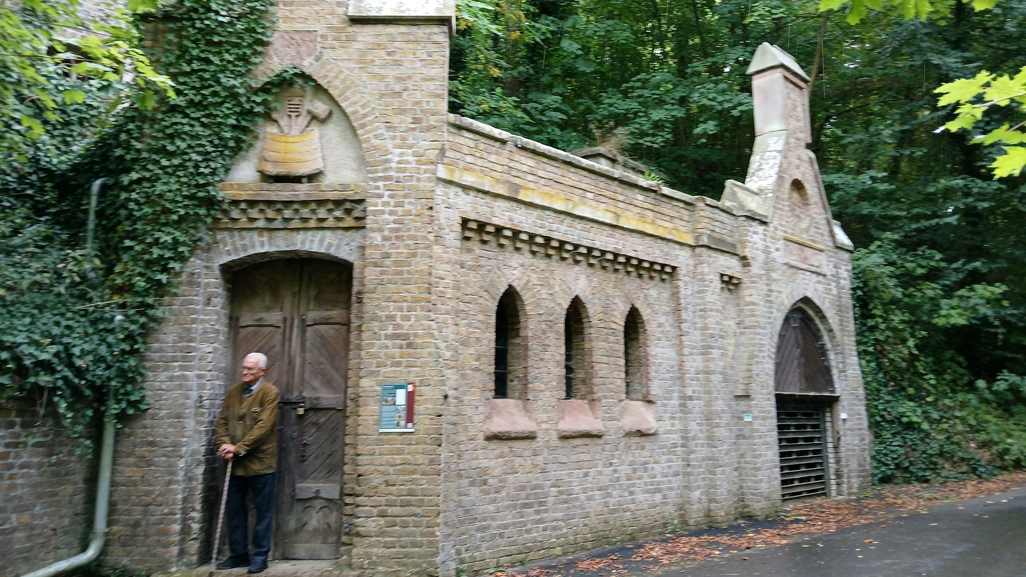 Ein Backsteinbau, der von Bäumen umgeben ist, bildet die Eingangsschleuse zum Eiskeller von Bürvenich.